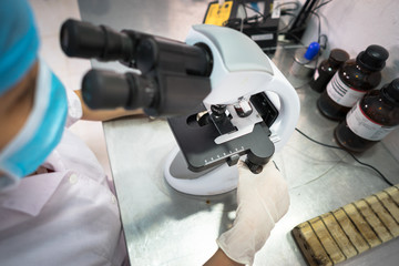 Asian technician tests the quality of product in laboratory closeup
