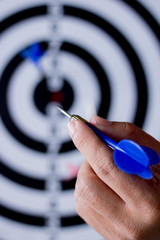 hand holding dart to goal on board with  background .