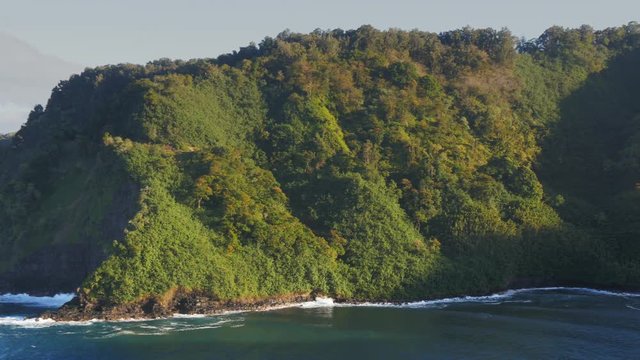 a panning shot of maui's honomanu bay on the popular road to hana drive