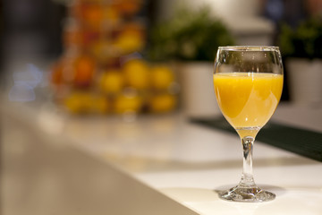 Glass with orange juice on the bar in the restaurant
