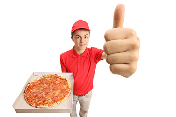 Teenage pizza delivery boy holding a pizza and making a thumb up gesture