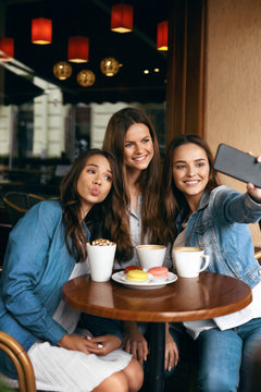Beautiful Friends Taking Photos In Cafe.