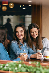 Happy Women Using Phone In Cafe.