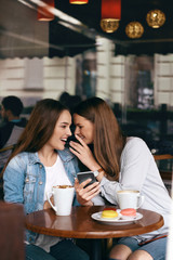 Girls Gossip. Friends With Coffee Speaking In Cafe.