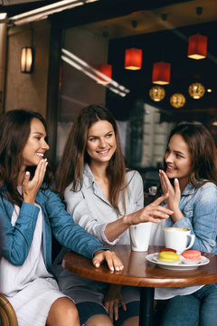 Girls Gossip. Friends With Coffee Speaking In Cafe.