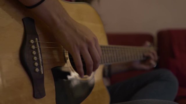 Girl practicing percussive guitar techniques, strumming and slapping.