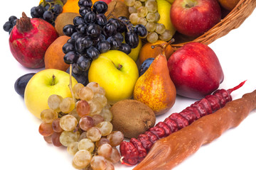 apples and other fruits in a wicker basket on a white background