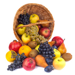 apples and other fruits in a wicker basket on a white background