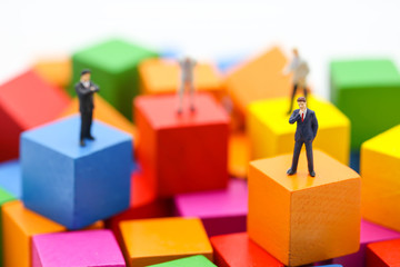 Miniature people : businessman standing on wood color block, using as background , business concept
