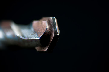 Concrete drill bit close up macro shot isolated on black background.