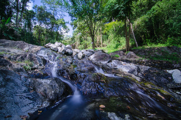 Naklejka na ściany i meble A small little waterfall falling on a small lake in Thailand