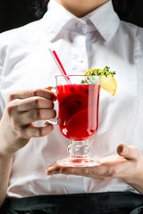 The unidentified waiter holding a glass with hot cranberry gin with anise and cinnamon