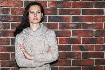 Portrait of the young woman up to shoulders at a wall