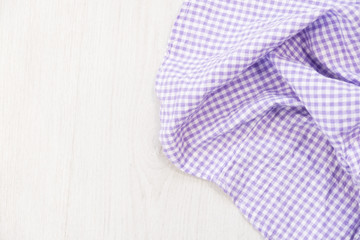 folded cyan tablecloth on bleached wooden table