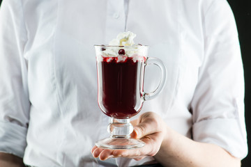 The unidentified waiter holding a glass cocktail with whipped cream and lemon juice