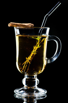 Hot Amaro cocktail with apple juice and cinnamon on dark background