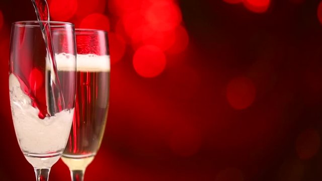 Valentine's Day celebration. Champagne pouring over holiday blinking background. Slow motion 4K UHD video footage. 3840X2160