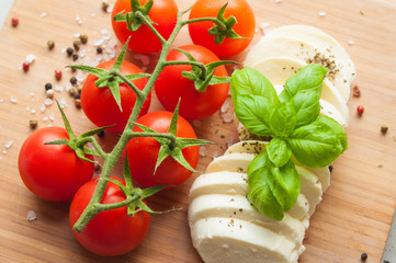  mozzarella cheese with basil and cherry tomatoes on a stone table