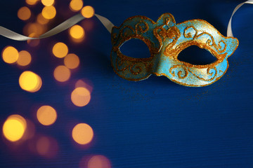 Image of elegant blue and gold venetian mask over blue background.