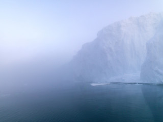 Huge icebergs on arctic ocean in foggy day