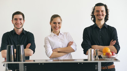 Professinal bartender man and woman smiling at mobile bar table on white background studio