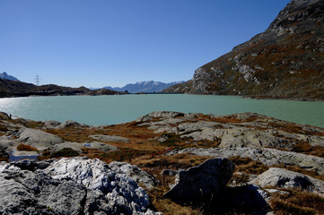 Fototapeta na wymiar Der Bernina Express auf dem Hospitz beim Lago Bianco in der malerischen Gebirgslandschaft der Schweizer Alpen.