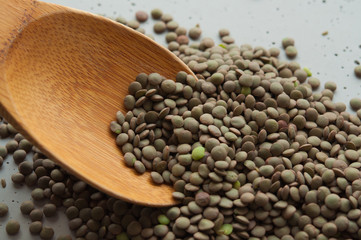 green lentil grains on a wooden spoon