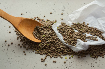 green lentil grains on a wooden spoon