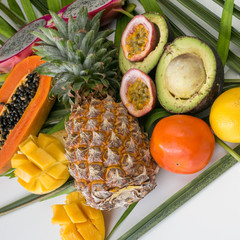 Fresh, exotic, organic fruits on white background. Fruit, papaya, pineapple, dragon fruit, avocado, mango, passion fruit. Asia. Thailand. Not beautiful. Palm leaf