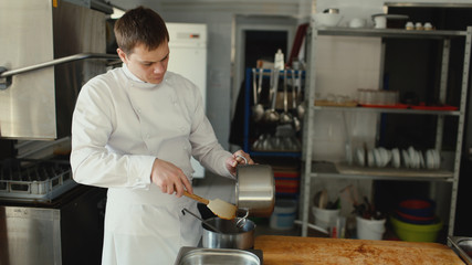 Professional chef man prepare gravy sauce with spices at restaurant kitchen