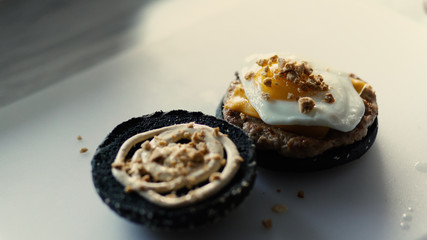 Closeup of grilled black burgerwith sauce and eggs on kitchen board