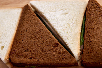 White and black bread. Sandwich with ham. Green salad