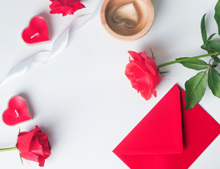 Red roses, envelope, heart shaped candles on the white background