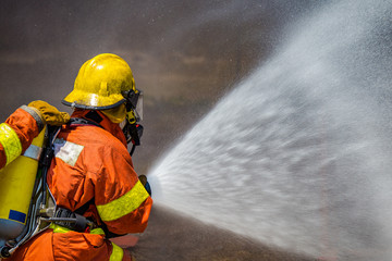 firefighter water spray by high pressure fire hose