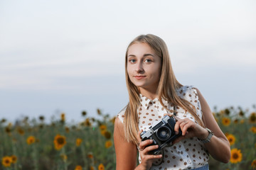 beautiful young girl photographer with photo camera on nature