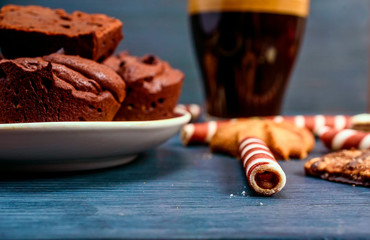 chocolate muffins, wafer tubules and fresh fragrant coffee. still life on a dark wooden background. 