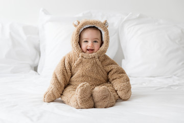 smiling baby wearing bear suit