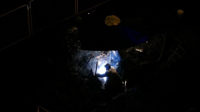 Working with gas welding welded pipe in the shed at night, view from above.