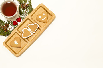 Valentines day concept: Cookies in heart shape symbolize Love decorated with glass of tea and green pine branches isolated on white background. Top view. Macro, close up.