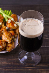 Beer and chicken wings buffalo with blue cheese and celery sticks, vertical