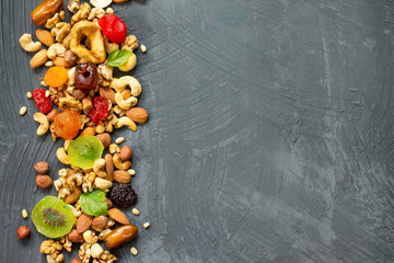 Various dried fruits and mix nuts on a gray stone or slate background.  The concept of the Jewish...