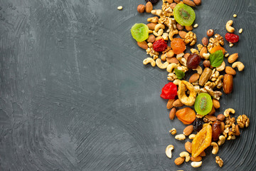 Various dried fruits and mix nuts on a gray stone or slate background.  The concept of the Jewish...