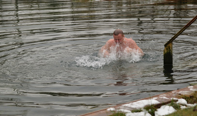 Man  is swimming  in lake in winter