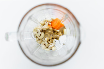 blender glass, ingredients for a vegan cashew sauce, top view, selective focus