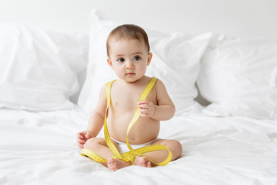cute baby holding a measuring tape