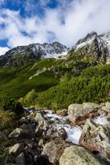 large Waterfall from ravine in autumn, long exposure with mountains in background