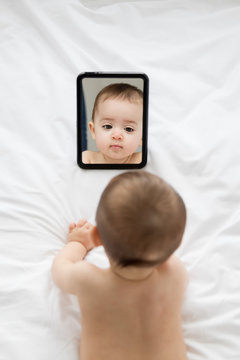 baby looking at herself in the mirror seen from above