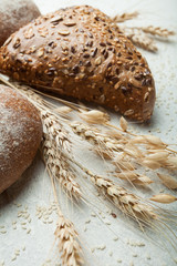 Freshly baked bread with spikelets of cereals in a country setting.