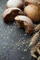 A piece of freshly cut rye bread and bread on a black background.