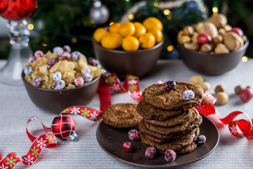 freshly baked chocolate chip cookies on a table with blurred christmas tree background.
